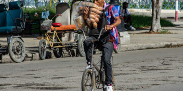 Un hombre carga bolsos de pan en una bicicleta en La Habana. Foto: Otmaro Rodríguez.