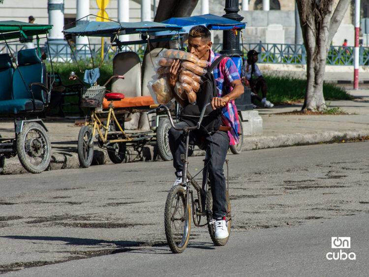 Un hombre carga bolsos de pan en una bicicleta en La Habana. Foto: Otmaro Rodríguez.