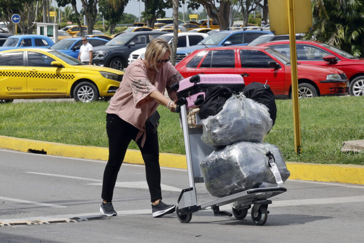 Una mujer lleva su equipaje en el aeropuerto internacional José Martí, en La Habana. Foto: Ernesto Mastrascusa / EFE.