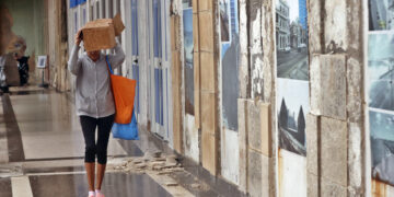 Una mujer se protege de la lluvia durante un frente frío en La Habana. Foto: Ernesto Mastrascusa / EFE / Archivo.