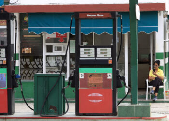 Una trabajadora revisa su teléfono móvil en una gasolinera estatal sin combustible en La Habana. Foto: Ernesto Mastrascusa / EFE / Archivo.
