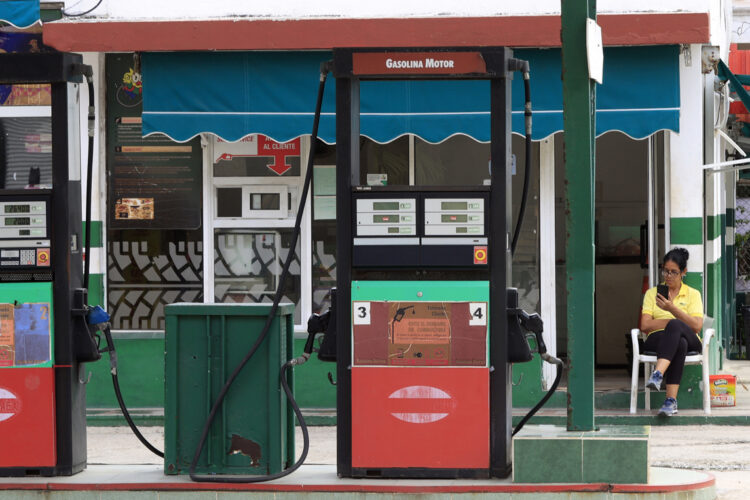 Una trabajadora revisa su teléfono móvil en una gasolinera estatal sin combustible en La Habana. Foto: Ernesto Mastrascusa / EFE / Archivo.